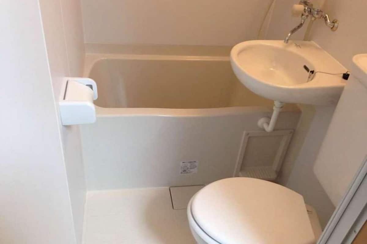 A small, white bathroom with a bathtub, a sink, and a toilet.