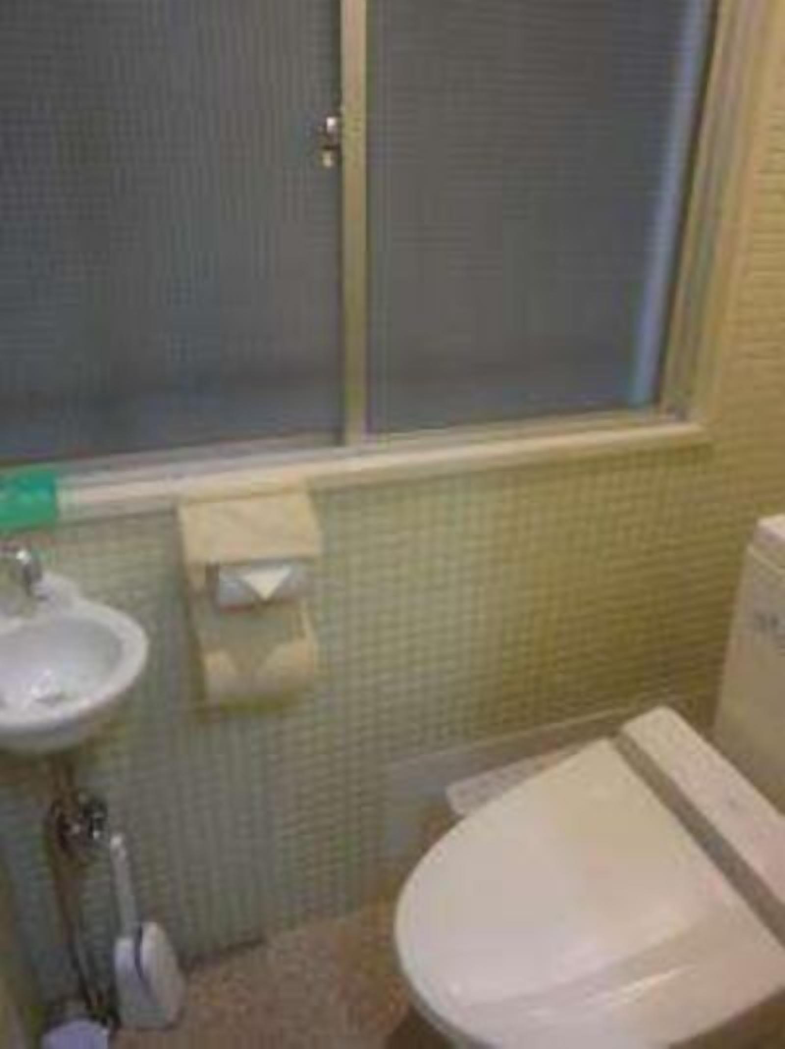 Un baño con inodoro, lavamanos y ventana.