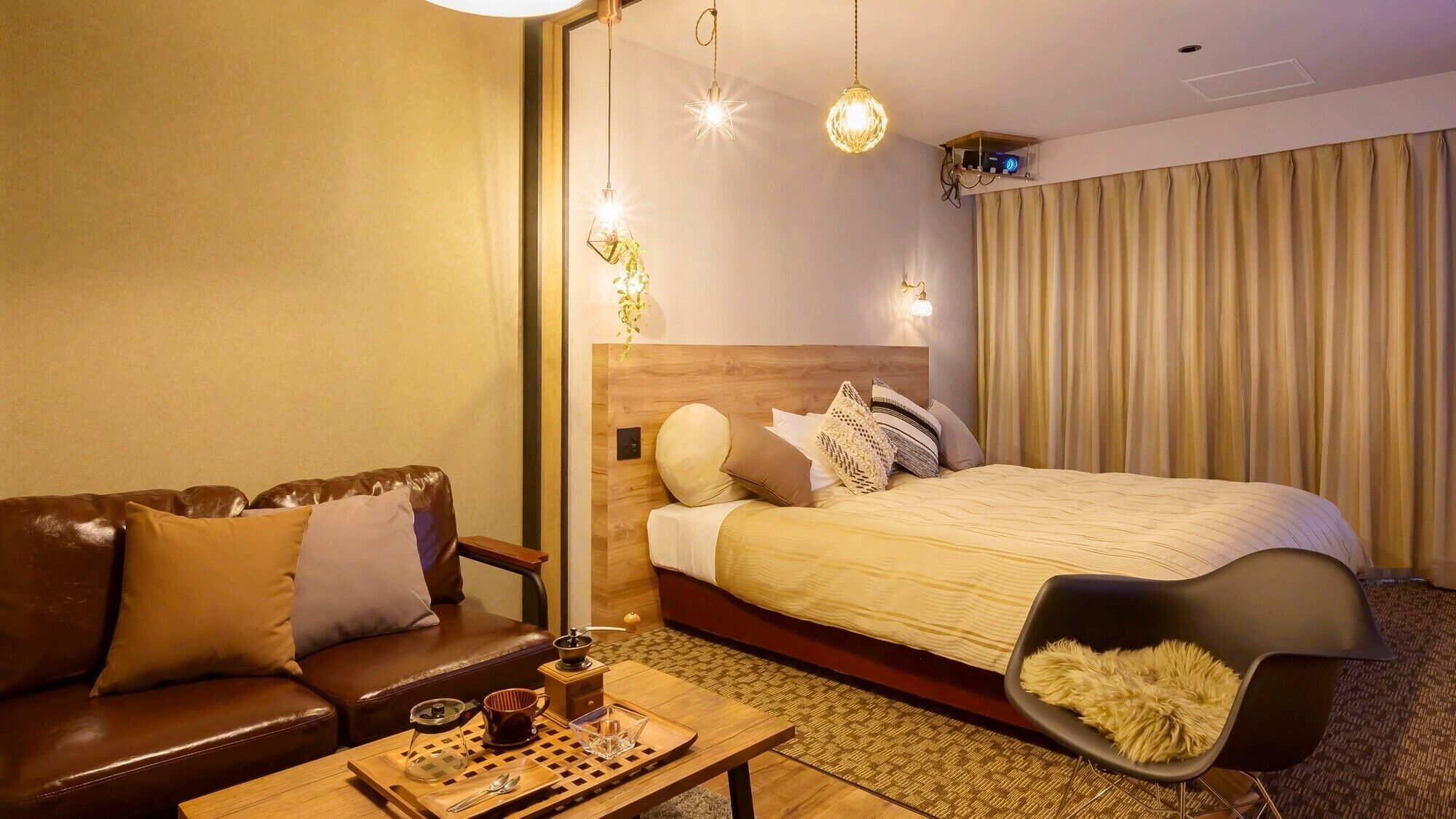 A hotel room with a bed, a sofa, a coffee table, and a TV.