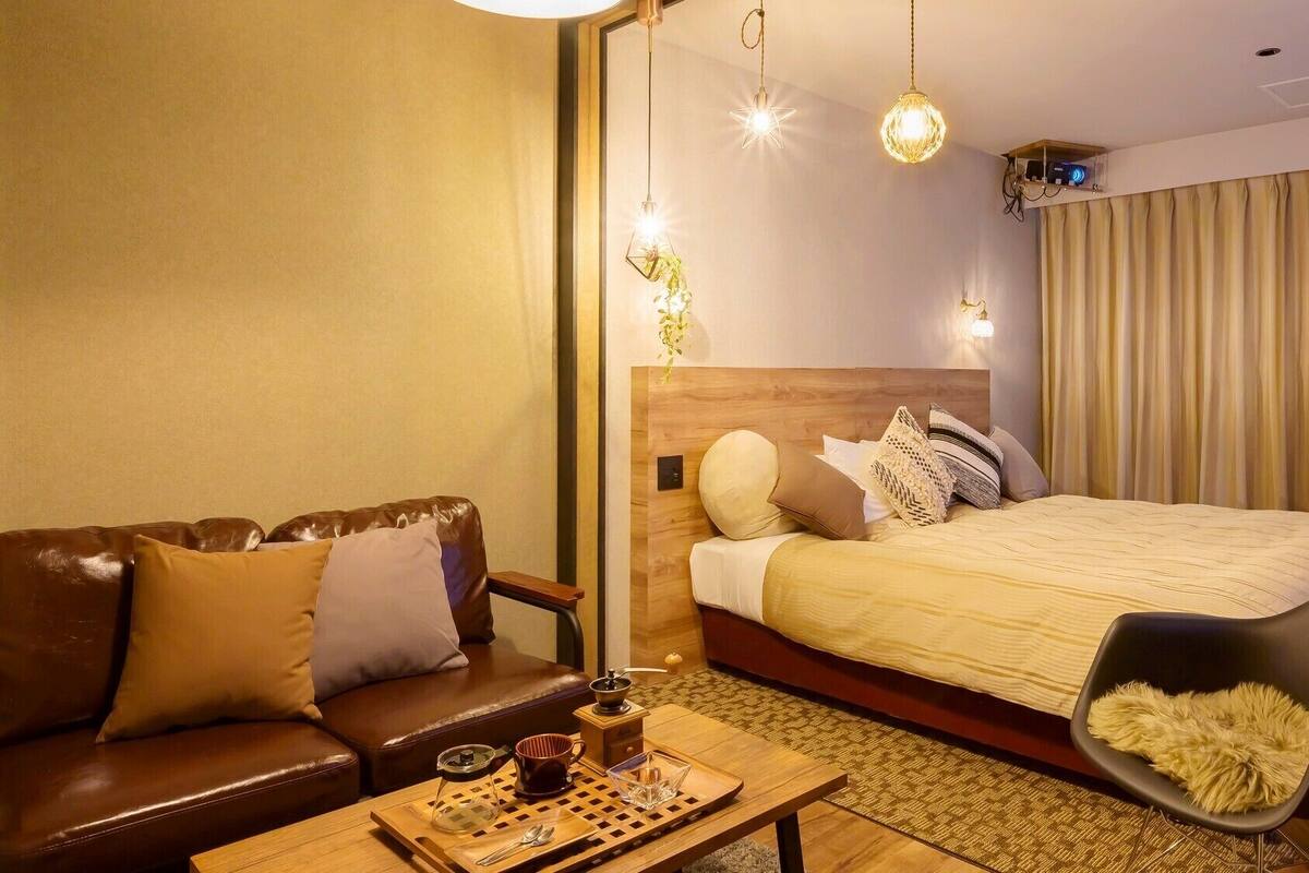 Une chambre d’hôtel avec un lit, un canapé, une table basse et un téléviseur.