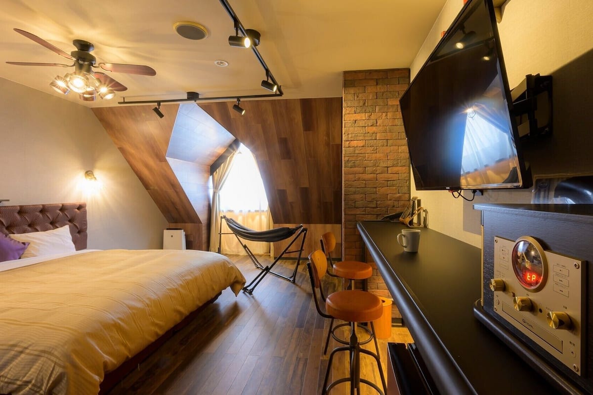 Une chambre d’hôtel moderne équipée d’un lit, d’une télévision, d’une machine à café et d’un coin bar.
