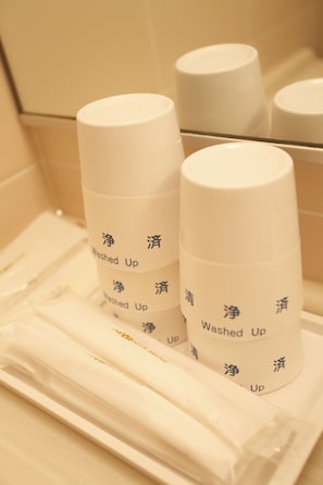 Two white cylindrical containers labeled "Washed Up" in both English and Chinese, placed on a white tray in a bathroom setting. - Hotel Edel Warme (Furano)