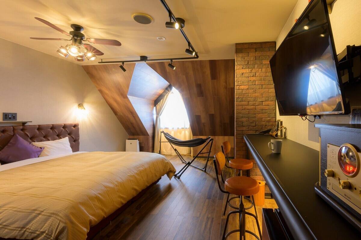Une chambre d’hôtel moderne équipée d’un lit, d’une télévision, d’une machine à café et d’un coin bar.