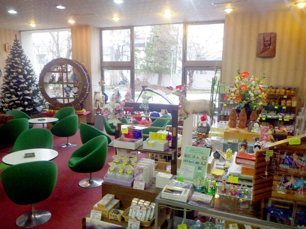 Un interior acogedor con sillas verdes, un árbol de Navidad y varios objetos en estantes.