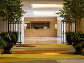 A reception area with a wooden reception desk, two lamps, and a bookshelf. - Francs (Chiba)