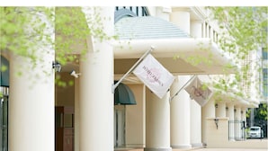 Entrada de hotel con columnas, un corredor cubierto y banderas con la leyenda "HOTEL FRANCS".