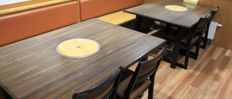 A dining area with wooden tables and cushioned booths.