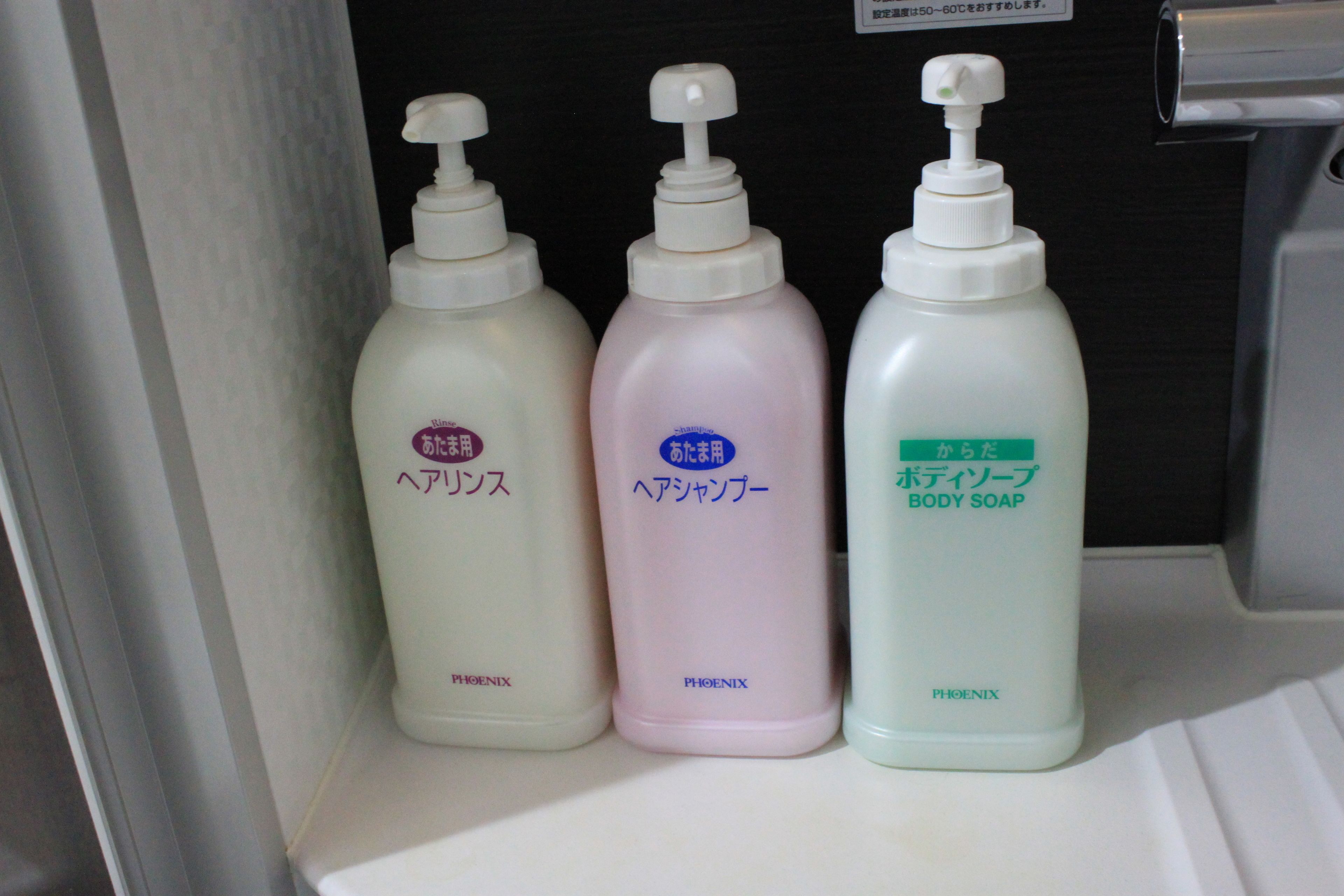 Tres botellas de jabón de baño sobre una estantería.