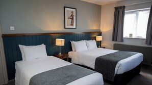 A hotel room with two beds, a framed picture on the wall, and a window with curtains. - Cocked Hat Hotel by Greene Kings Inns (Coventry)