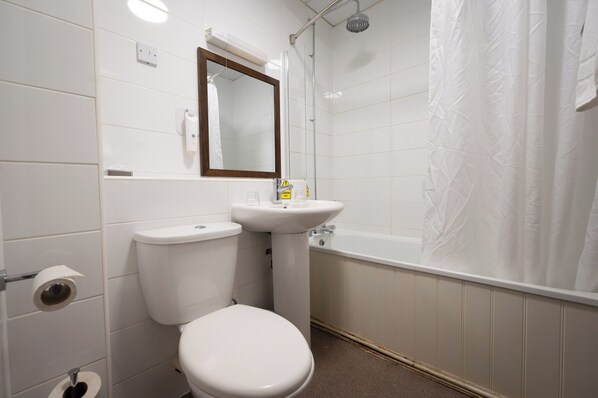 A bathroom with a toilet, sink, and shower.