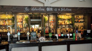 A bar with a sign stating "By definition BEER is a solution" and various beer taps. - Cocked Hat Hotel by Greene Kings Inns (Coventry)