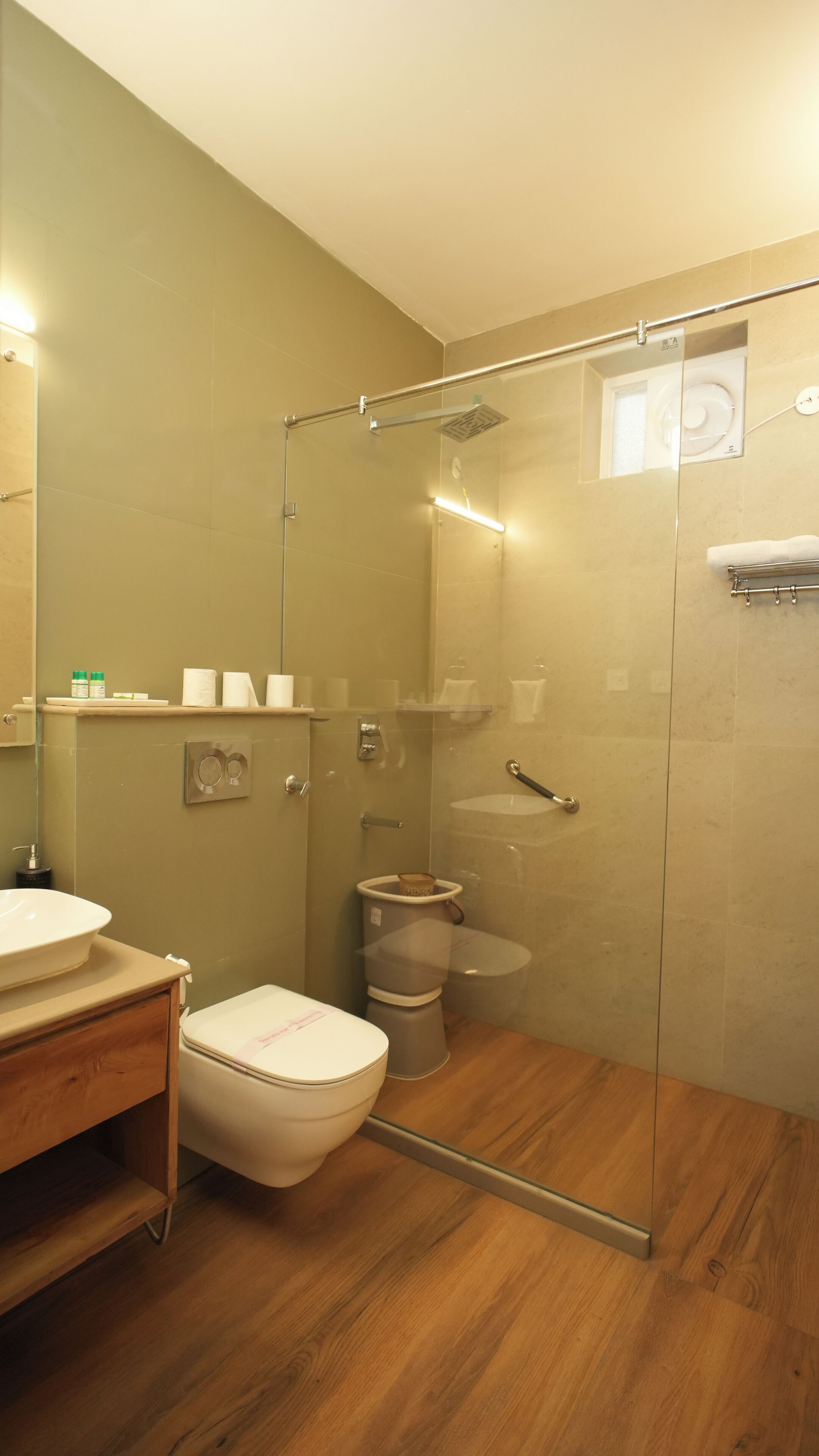 Un baño con ducha de mampara de vidrio, inodoro, lavabo y espejo.