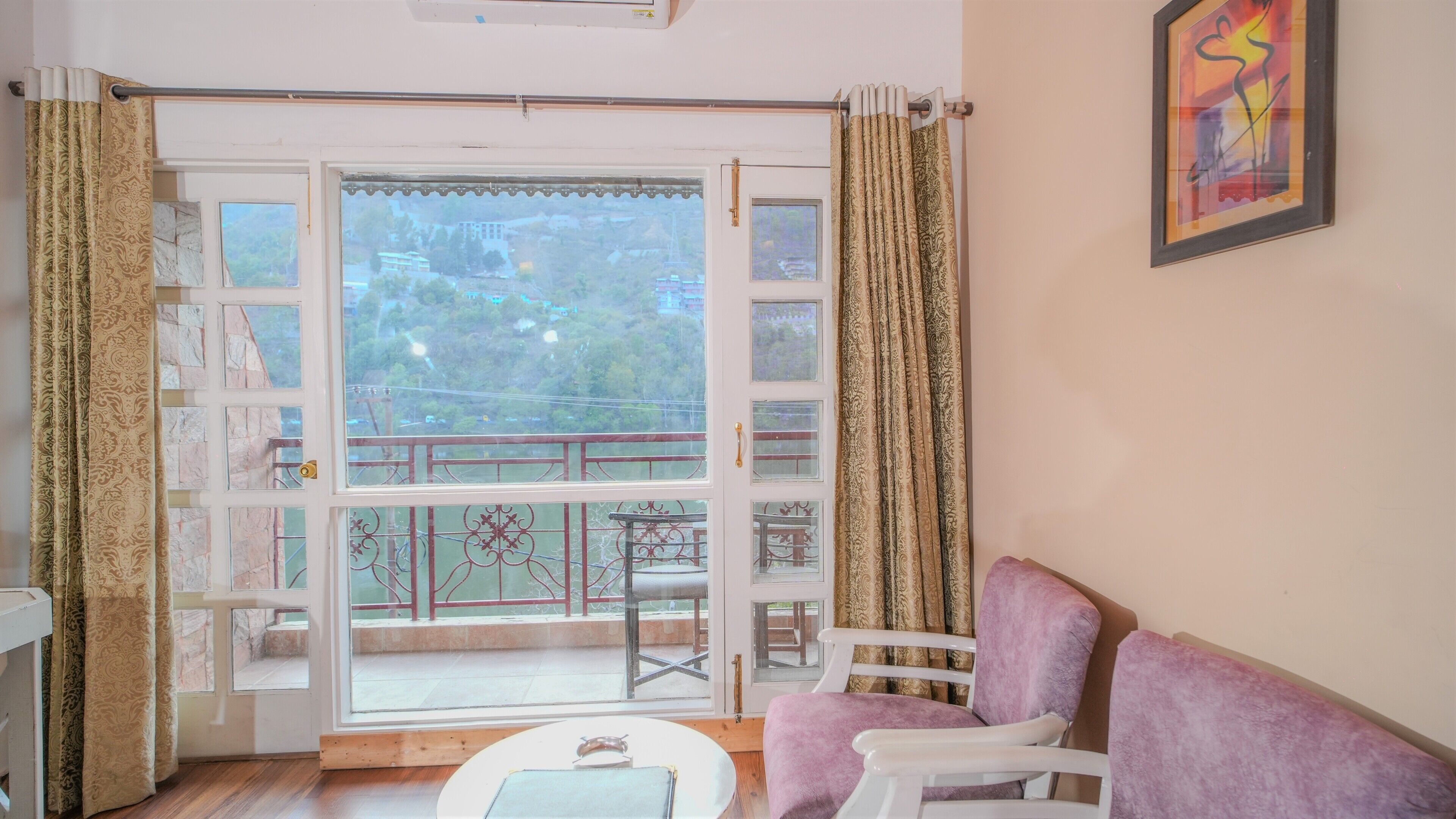 Une pièce avec un balcon, un canapé blanc et une petite table.