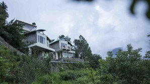 A multi-story house with a stone facade, large windows, and a balcony. - Seclude Ramgarh, Cliff's Edge (Kosiyakutoli)