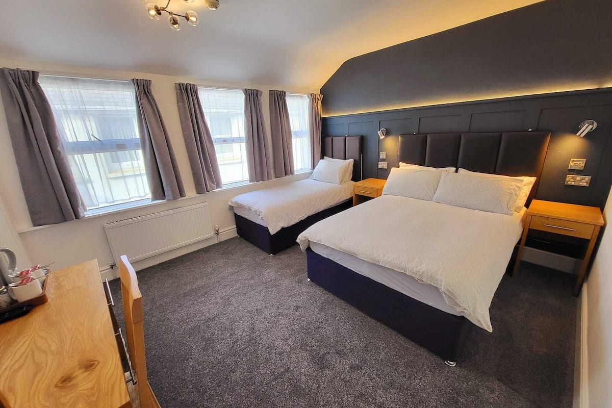 Ett hotellrum med två sängar, ett skrivbord och en stol.