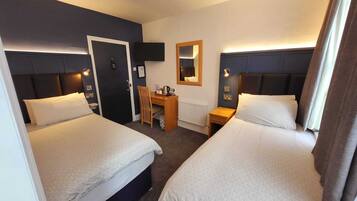 A hotel room with two beds, a desk, a chair, a TV, and a mirror.