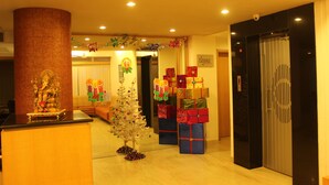 Un vestíbulo con una recepción, un árbol de Navidad y una fila de cajas de regalo apiladas.