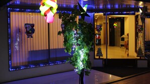 Un edificio con un árbol de Navidad adornado con luces, un adorno colgante colorido y una decoración de Papá Noel en la ventana.