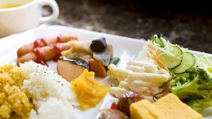 Une assiette de nourriture composée de riz, de tofu, de légumes et de viande.