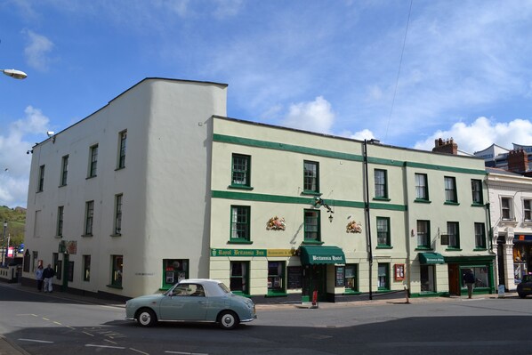 A building with a green and white facade, featuring the Royal Britannia Inn and a nearby restaurant. - The Royal Britannia (Ilfracombe)