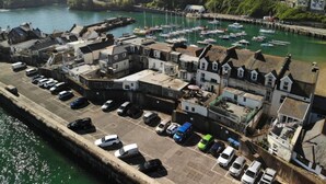 A coastal town with a marina, parked cars, and buildings with traditional architecture. - The Royal Britannia (Ilfracombe)