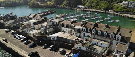 A coastal town with a marina, parked cars, and buildings with traditional architecture.