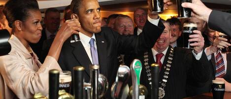 A group of people toasting with Guinness beer glasses.