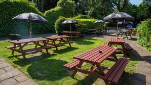 An outdoor patio area with picnic tables and umbrellas. - Old Grey Mare Hotel by Greene King Inns (Hull)