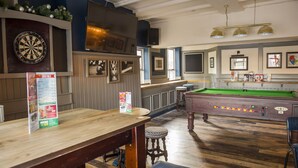 A bar area with a dartboard, billiards table, and wooden bar counter. - Old Grey Mare Hotel by Greene King Inns (Hull)