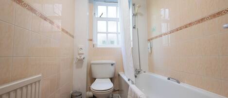 Une salle de bain avec des toilettes, une baignoire et une fenêtre.
