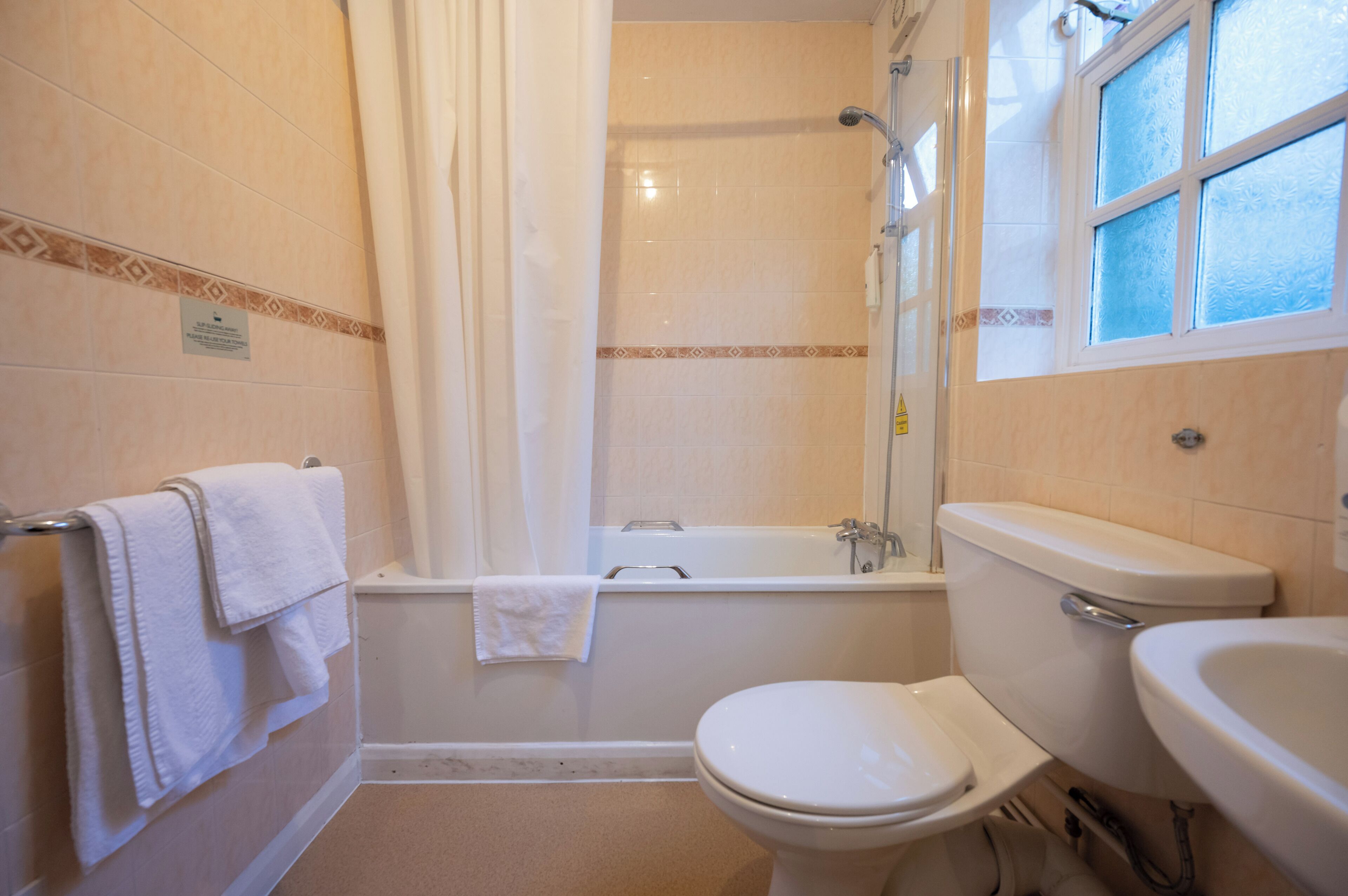 A bathroom with a bathtub, toilet, and sink.