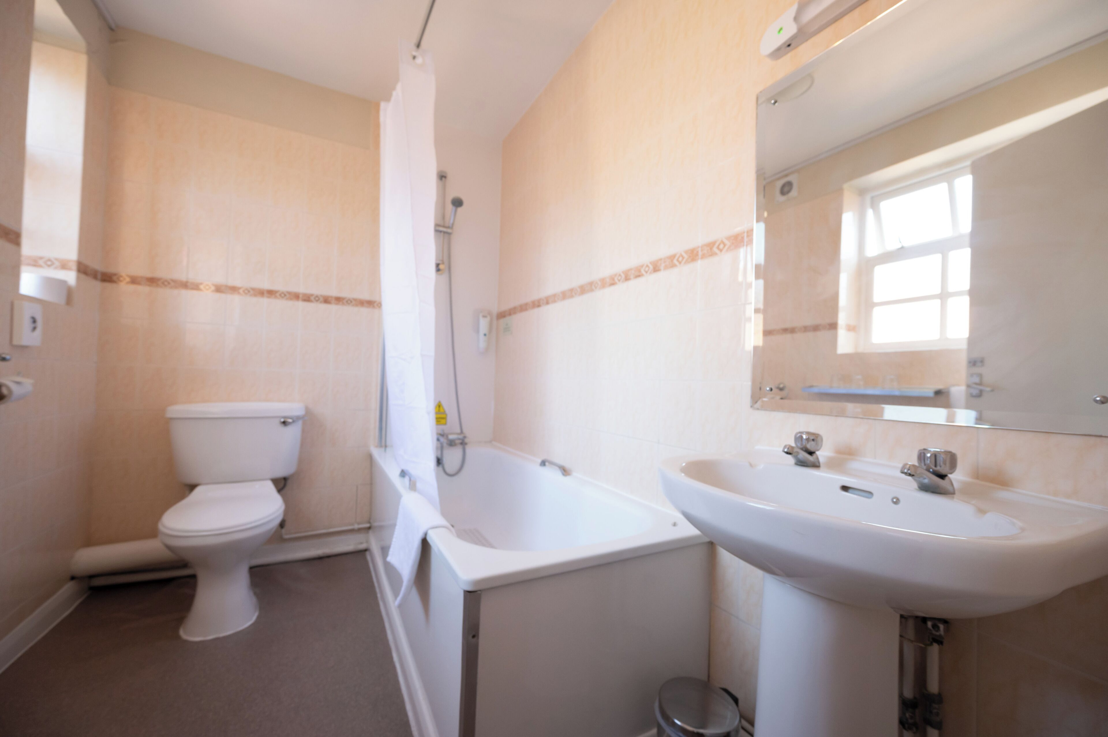 Un baño con inodoro, bañera y lavamanos.