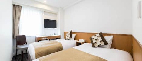 Une chambre d’hôtel avec deux lits, un bureau, une chaise, une télévision et une fenêtre avec des rideaux.