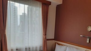 A hotel room with a bed, a window with sheer curtains, a wall clock, and a thermostat. - Toyoko Inn Kawasaki Ekimae Isago (KANAGAWA)