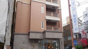 A multi-story hotel with a brown facade, a glass entrance, and a sign indicating it is a 10-minute walk from a subway station. - Toyoko Inn Kawasaki Ekimae Isago (KANAGAWA)