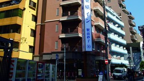 A multi-story building with a prominent vertical sign indicating it is a hotel. - Toyoko Inn Kawasaki Ekimae Isago (KANAGAWA)