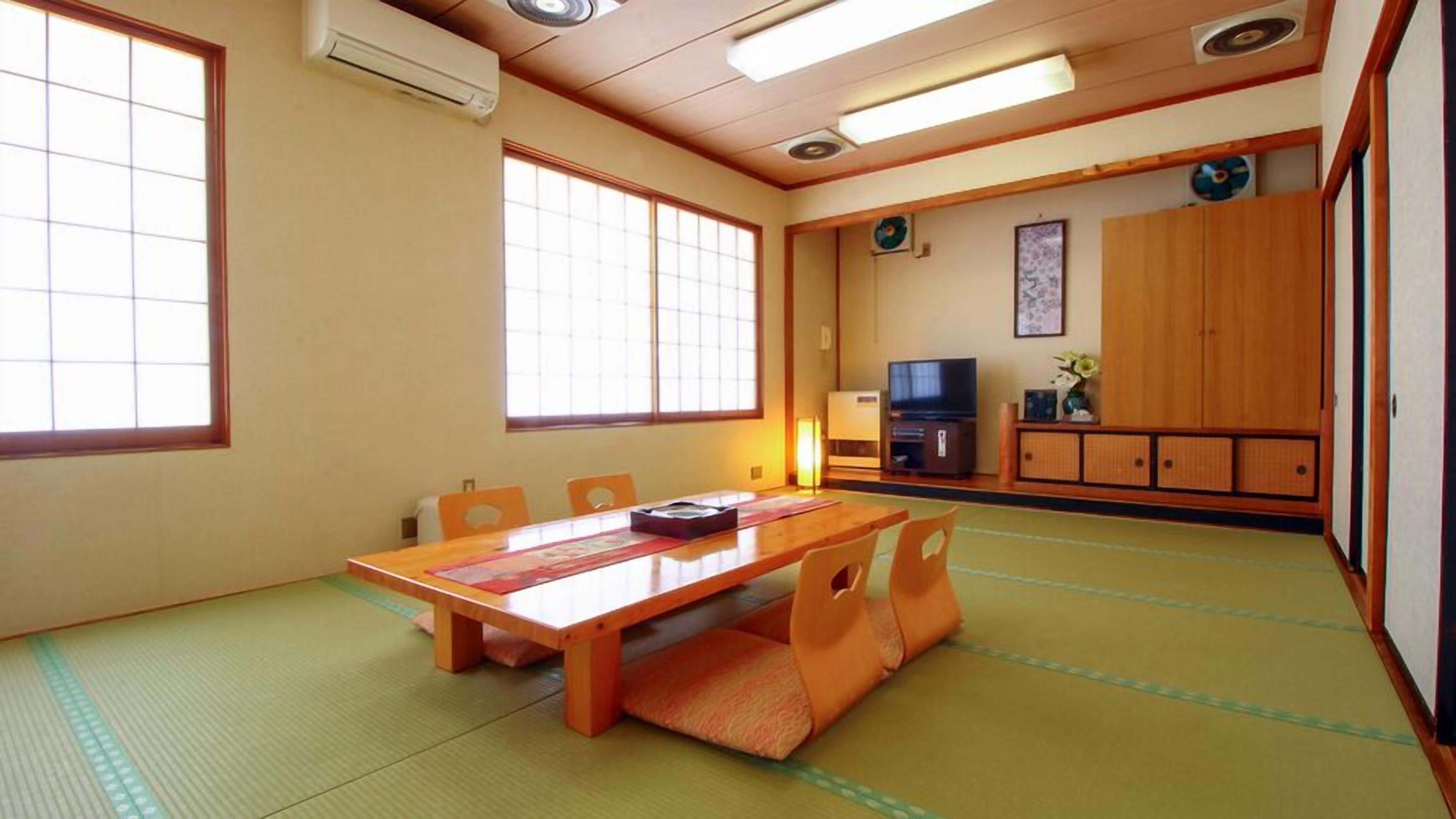 Une pièce de style japonais traditionnel, avec un sol recouvert de tatamis, une table basse et des portes coulissantes.