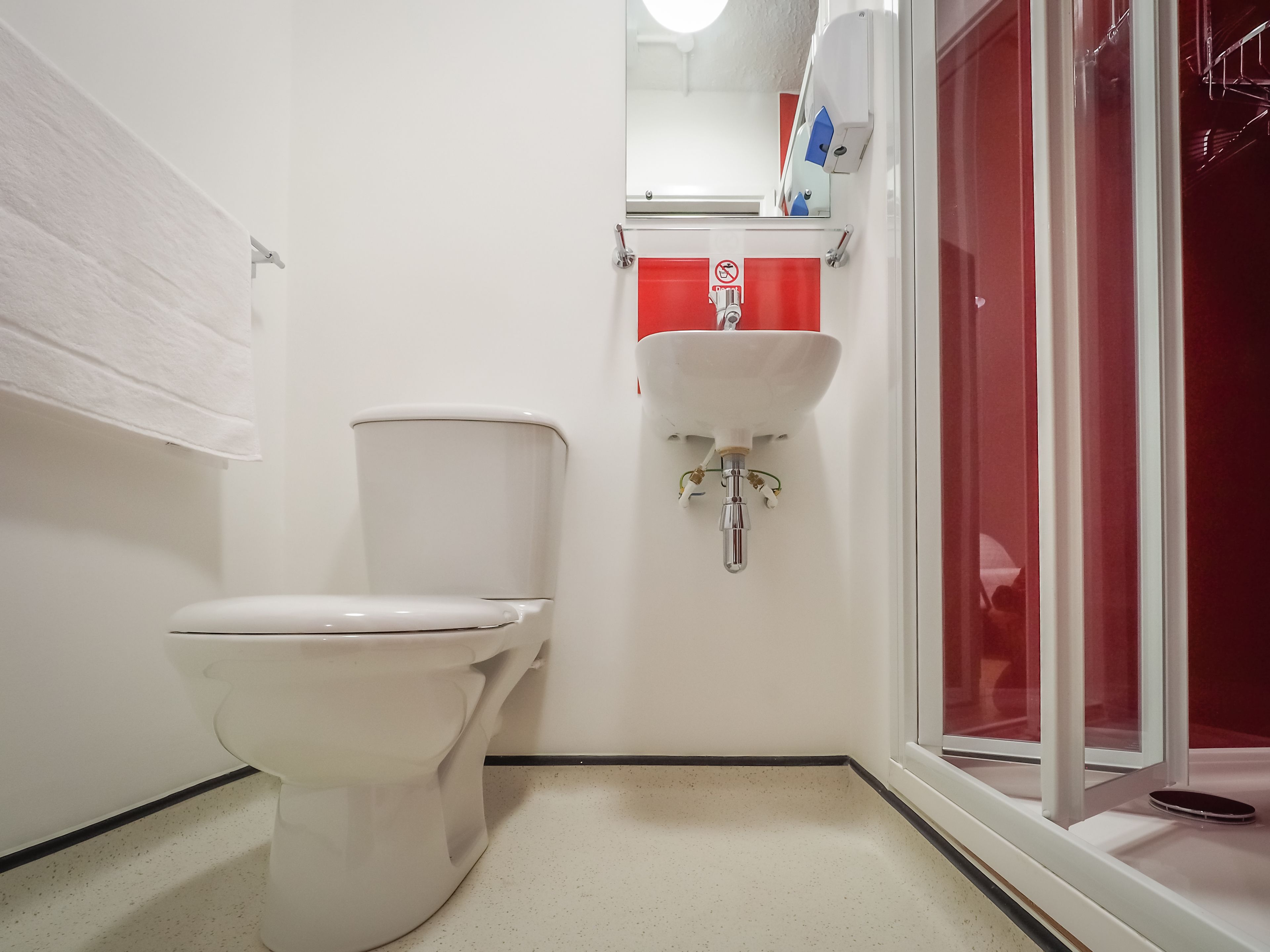 A bathroom with a toilet, a sink, and a shower area.