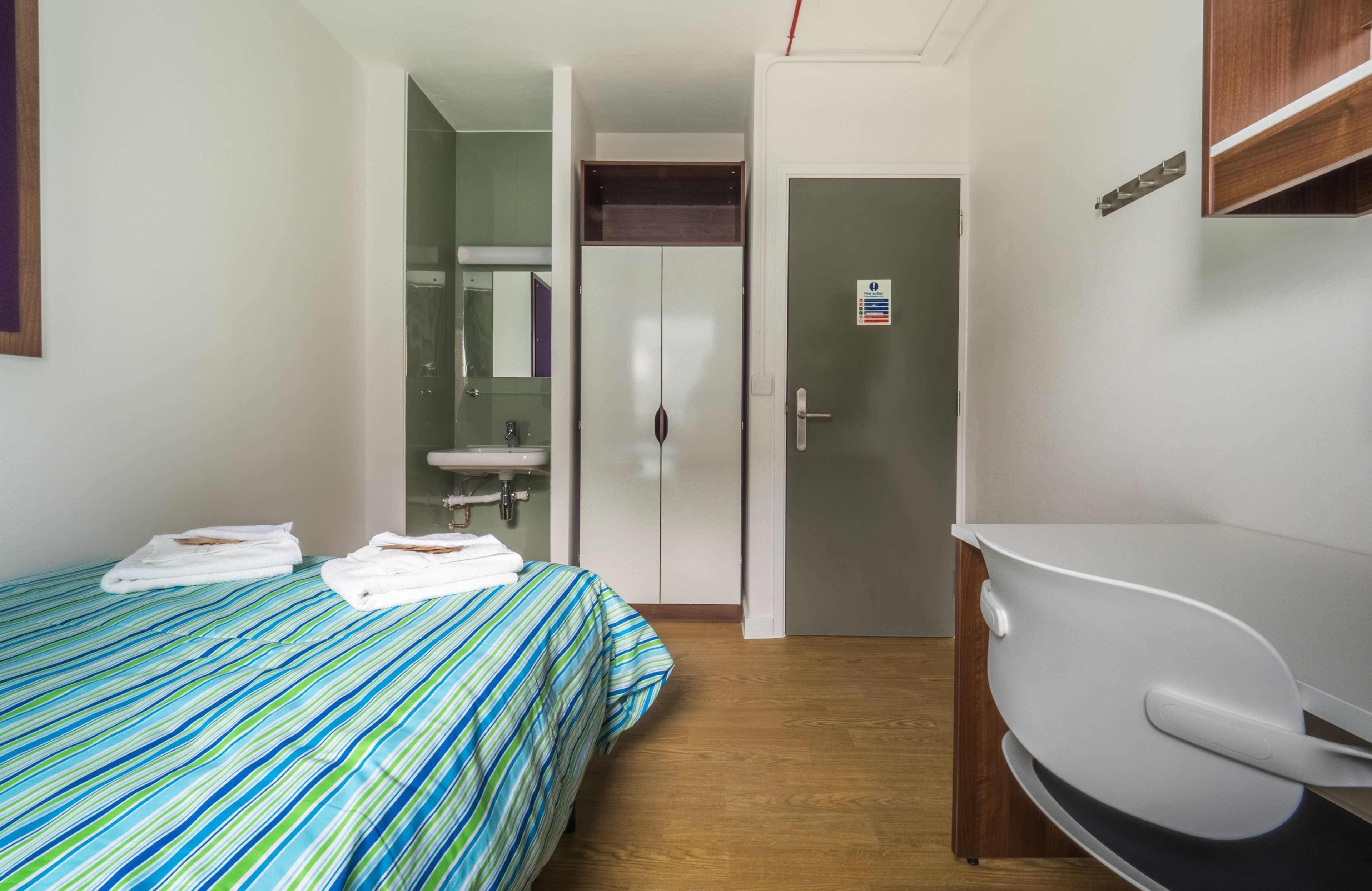 Una habitación de hotel con cama, baño y escritorio.