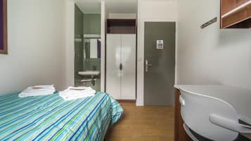 A hotel room with a bed, a bathroom, and a desk.