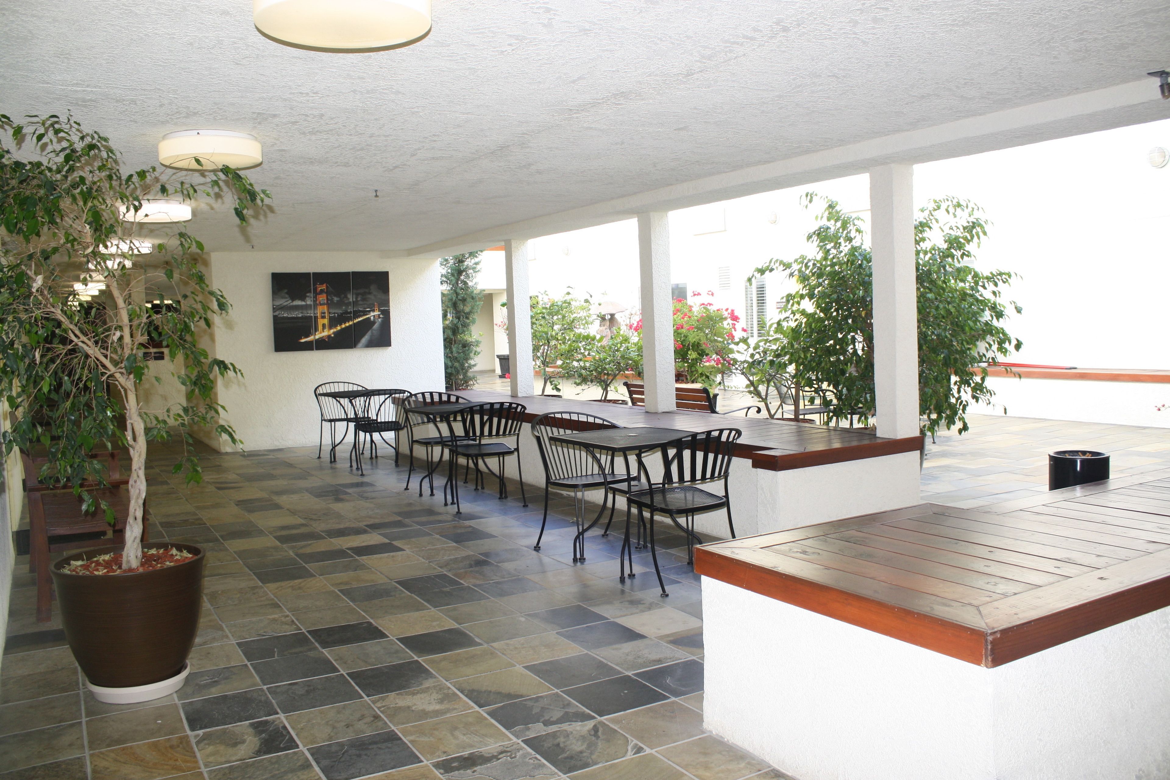 Une terrasse extérieure avec un espace repas, des plantes en pot et une vue sur le paysage urbain.
