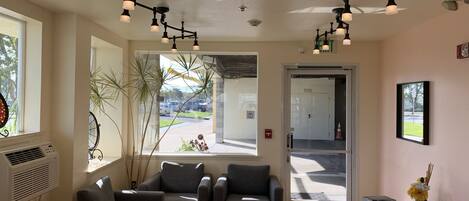 A reception area with a seating area, a large window, and a door leading outside.