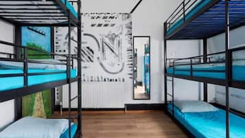 Habitación con literas, un radiador, un espejo y una pared con un diseño circular.