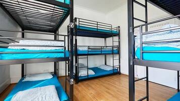 Un dormitorio con literas, numeradas del 4 al 7, y suelo de madera.