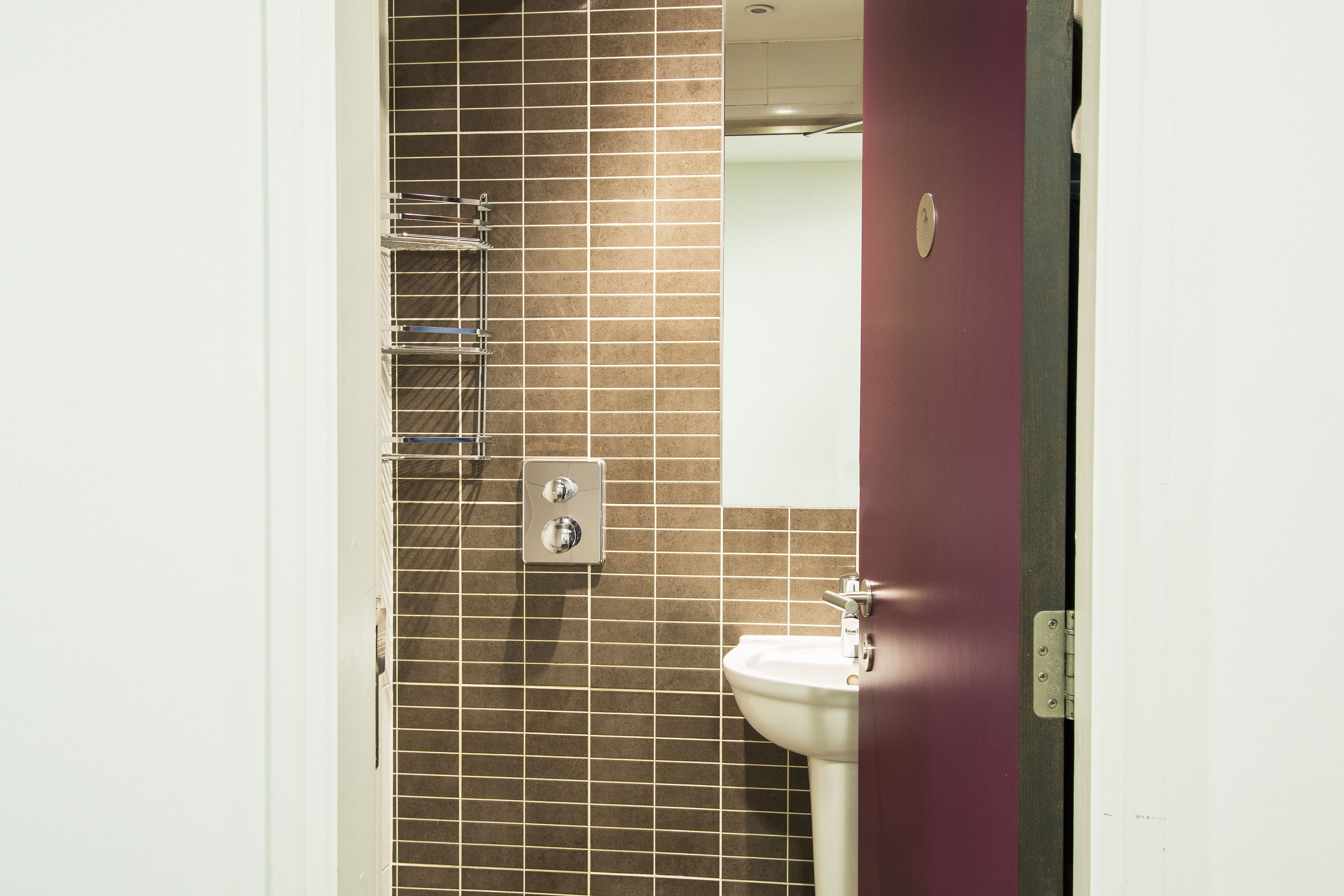 Une salle de bain avec un mur carrelé, un lavabo et un miroir.