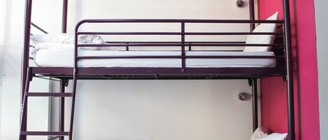 A bunk bed with white bedding and a ladder.