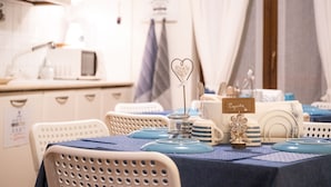 A dining area with a table set for two, featuring a blue tablecloth, white chairs, and a sign that reads "Magnolies". - B&B Patrizio (San Benedetto del Tronto)