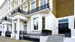 A white building with black iron railings and a black door. - Templeton Place by Supercity Aparthotels (London)