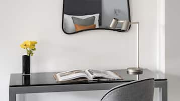 Un escritorio moderno con una silla, un espejo y platos decorativos en la pared.