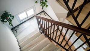 A staircase with wooden handrails and a white wall. - Abadi (Córdoba)